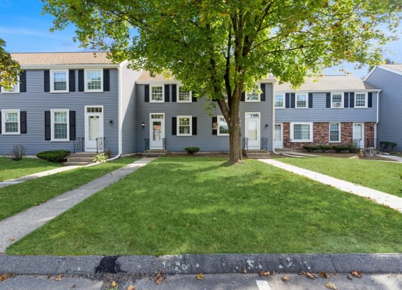 Front of apartments with sidewalks and landscape at Arbor Commons.