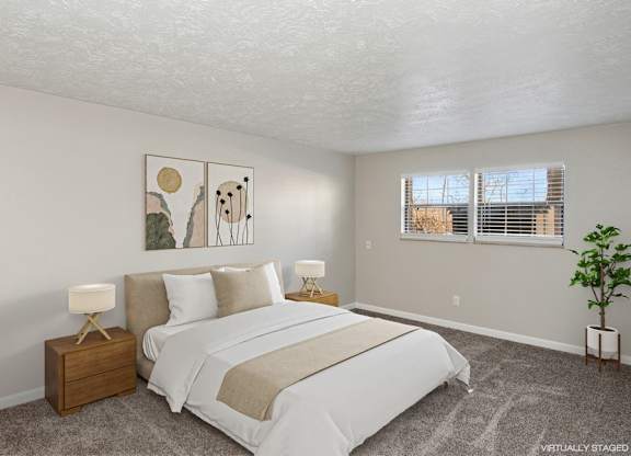 A bedroom with a large bed and two lamps.