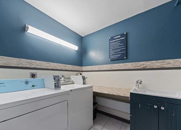 Laundry room with a blue wall and a white sink.