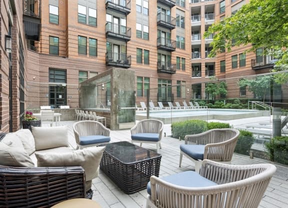 a patio with chairs and a table in front of a building