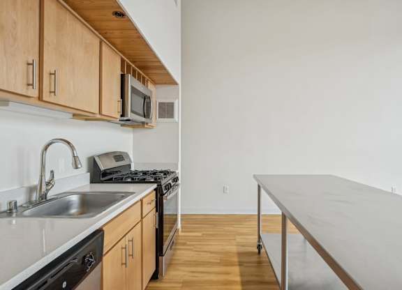 A kitchen with wooden cabinets and a stainless steel sink.