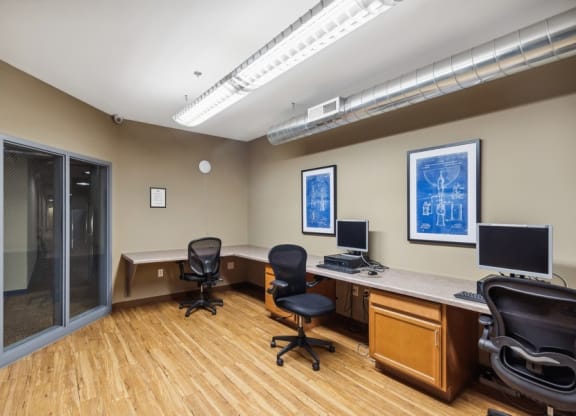 an office with two desks and two computer monitors
