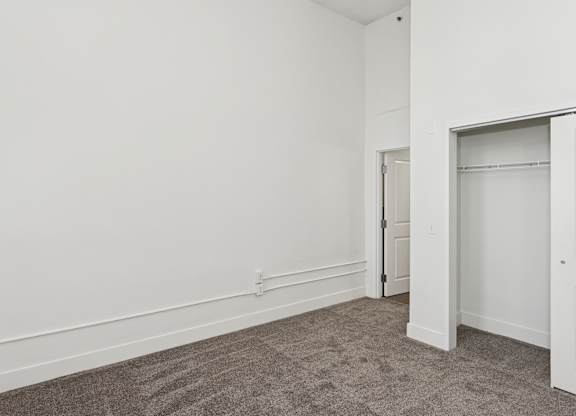 A room with a grey carpet and white walls.