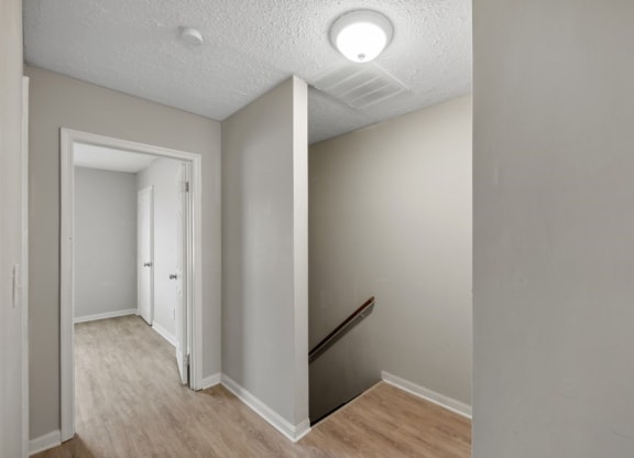 a hallway with wood floors and grey walls at Fort Collier Terrace, Virginia, 22601