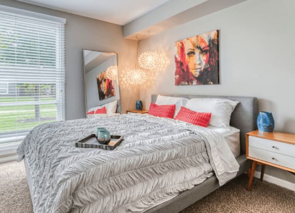 a bedroom with a large bed and a large window at The View Apartments St Charles, Illinois