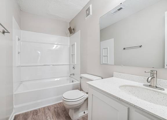 A white bathroom with a toilet, sink, and bathtub.