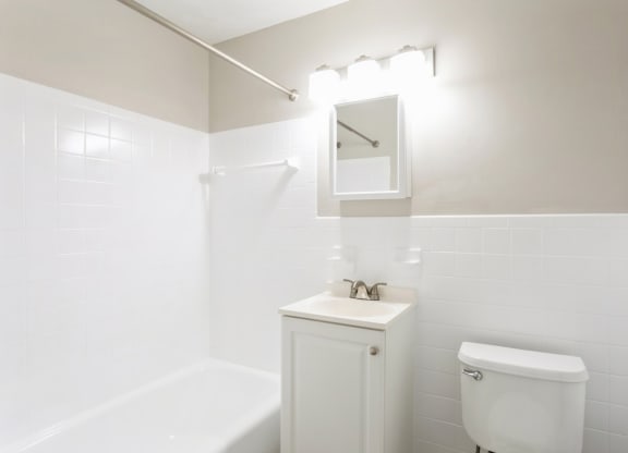 a white full bathroom with a white toilet and a sink at Stonebridge, Ellington, Connecticut