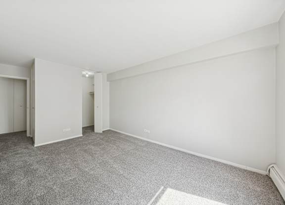 A room with a grey carpet and white walls.