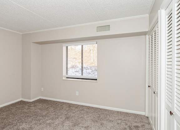 A spacious room with white walls and carpet