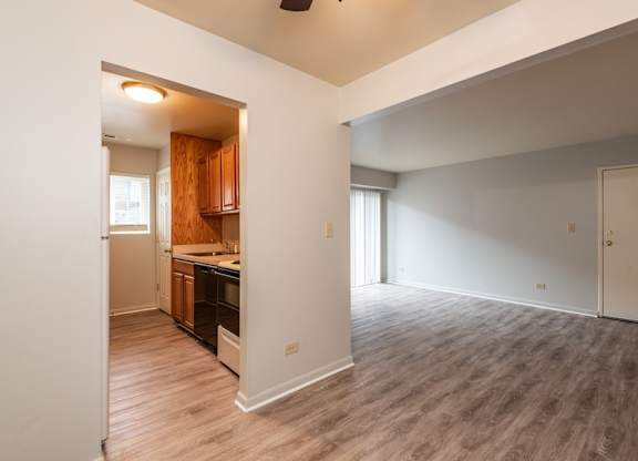 A room with a kitchen area and a dining table.