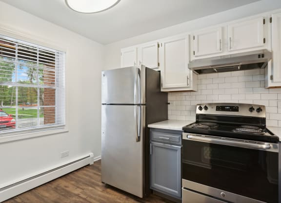 a kitchen with white cabinets and stainless steel appliances at The Hinsdale, Illinois, 60521