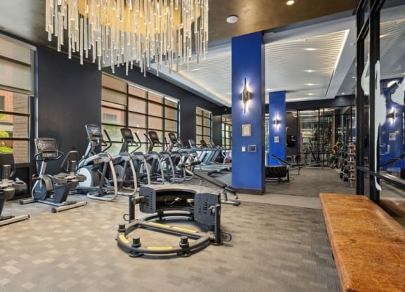 a gym with cardio machines and a chandelier