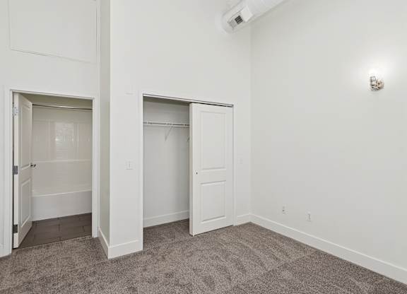 A room with two open doors and a carpeted floor.