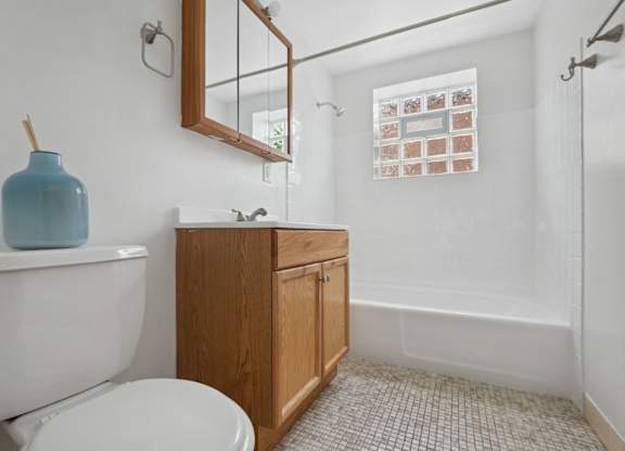 A white toilet sits next to a sink in a small bathroom.