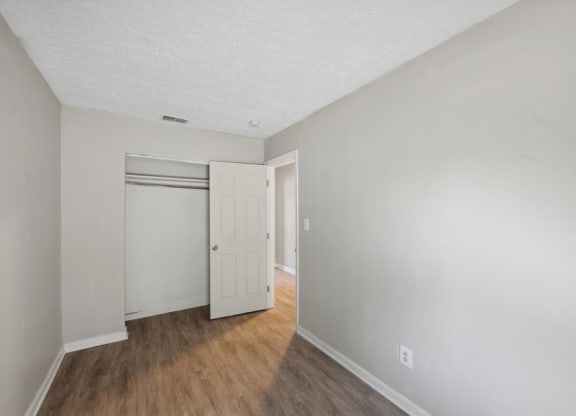 a bedroom with hardwood floors and grey walls at Fort Collier Terrace, Winchester
