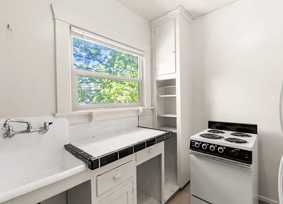 A white kitchen with tile countertops.