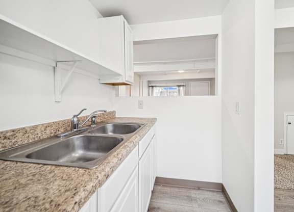 A kitchen with a granite countertop and white cabinets.
