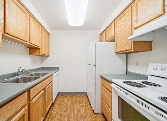 A kitchen with wooden cabinets and a white refrigerator.