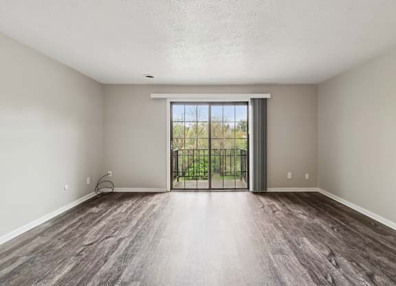 A room with a sliding glass door leading to a balcony.
