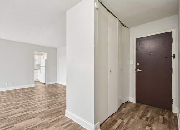 A room with a brown door and wooden floors.