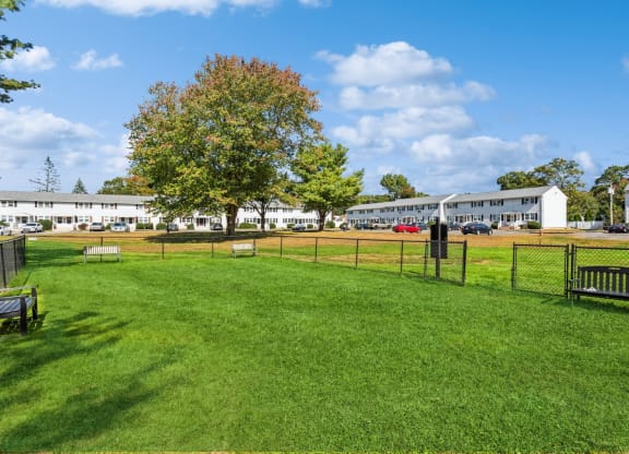 a dog park with benches and a fence in front of a building at Fox Hill Commons, Connecticut