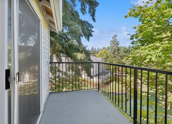 the balcony has a view of the yard and the street