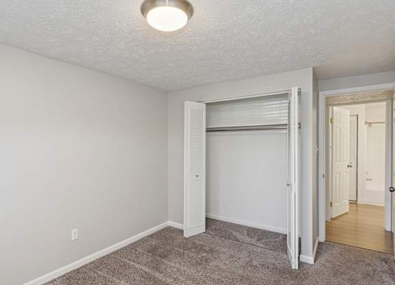 A room with a carpeted floor and a sliding door.