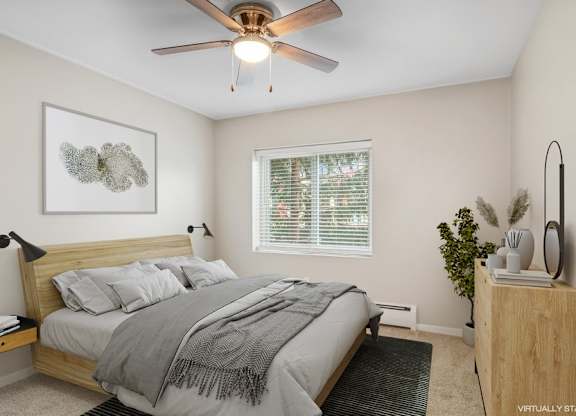 A bedroom with a bed, a ceiling fan, and a nightstand.