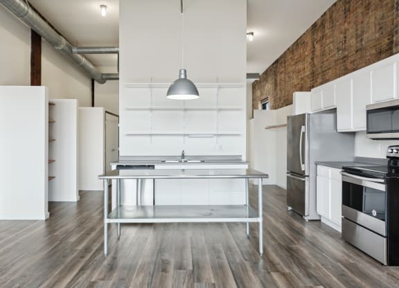 a kitchen with white cabinetry and stainless steel appliancesat Gaar Scott Historic Lofts, Minnesota