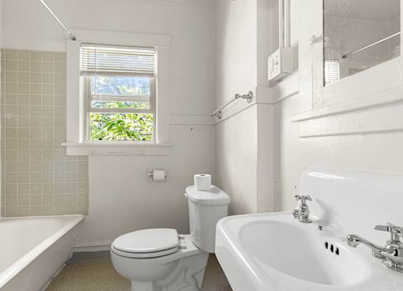 A bathroom with a toilet shower and sink.