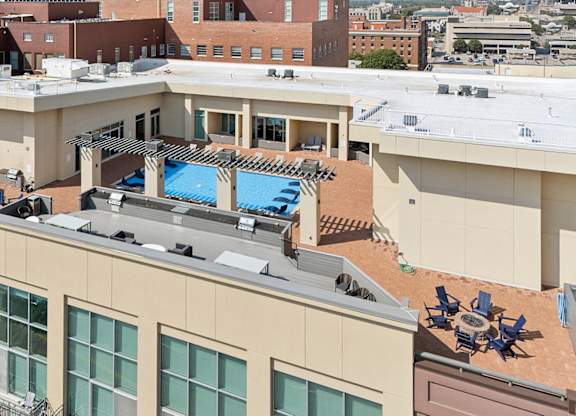 A rooftop with a pool and loungers.