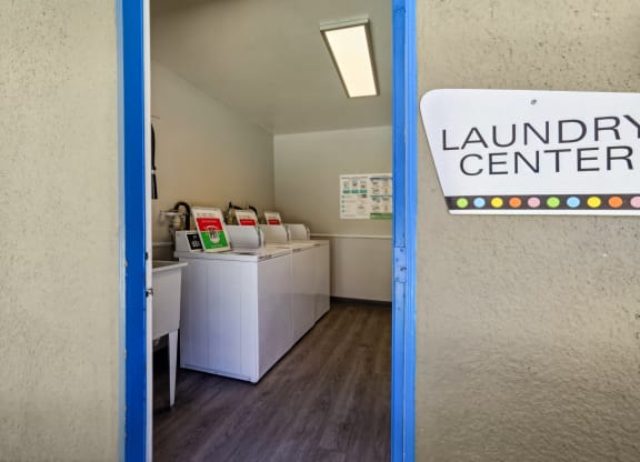 a laundry room with washing machines and a sign that reads laundry center