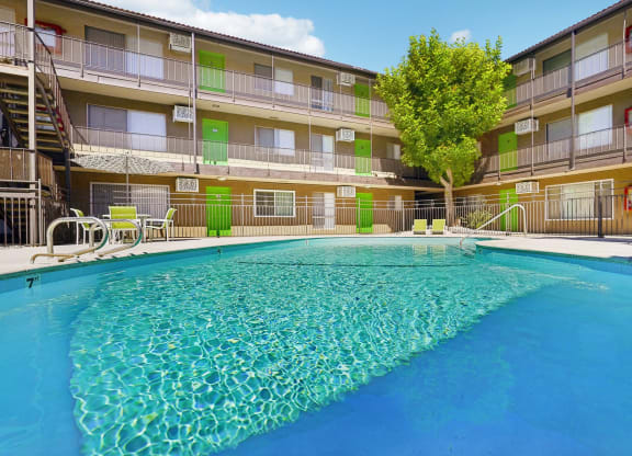 a resort style pool is in front of an apartment building