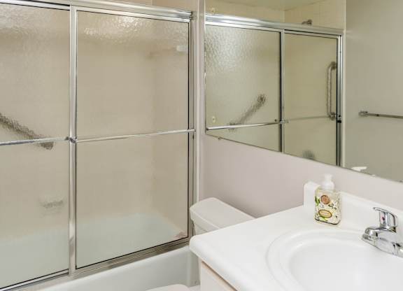 A clean bathroom with window sliding doors, a toilet and white sink