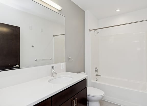 A white sink in a bathroom with a toilet and a shower.