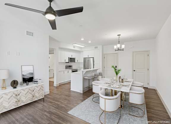 A modern dining room with a white table and chairs.