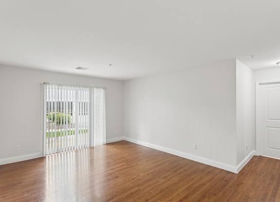 A room with wooden floors and white walls.