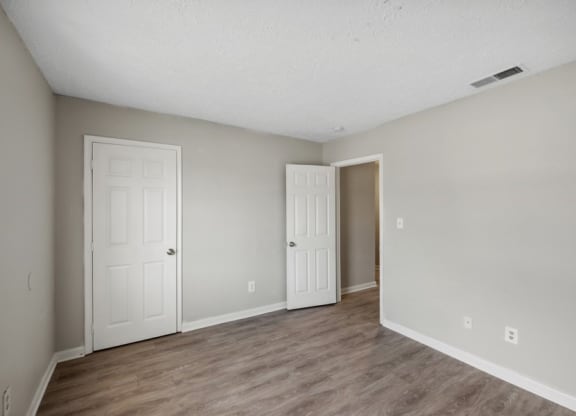 a bedroom with hardwood floors and grey walls at Fort Collier Terrace, Virginia