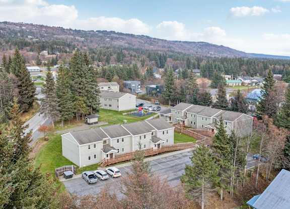 A large white building surrounded by trees and a parking lot.