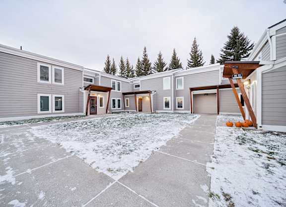 A row of houses with a snowy front yard.