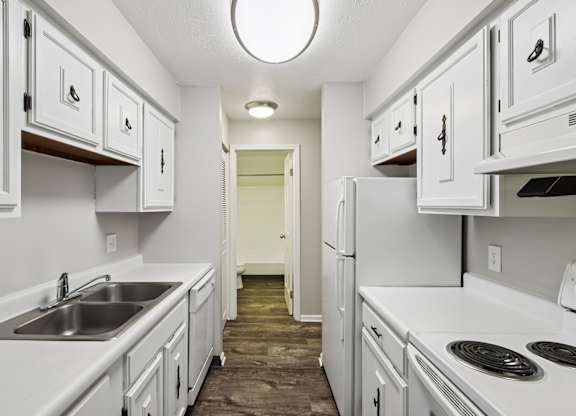 A kitchen with white cabinets and appliances.