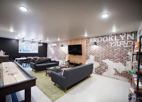 Community lounge with shuffleboard and seating at Brooklyn Yard Apartments, Portland, Oregon