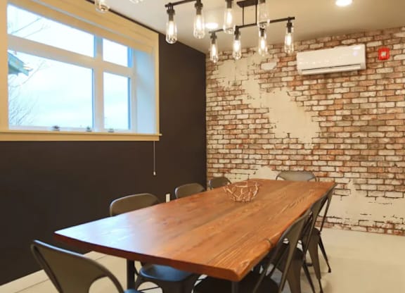 Conference room with exposed brick and wood table at Brooklyn Yard Apartments, Portland, OR 97202