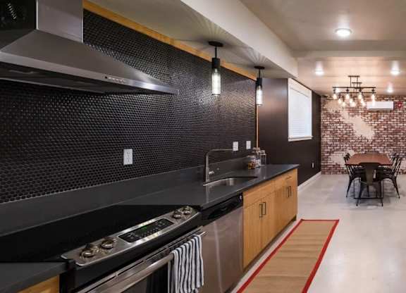 Modern basement kitchen with black penny tile backsplash at Brooklyn Yard Apartments, Portland, Oregon