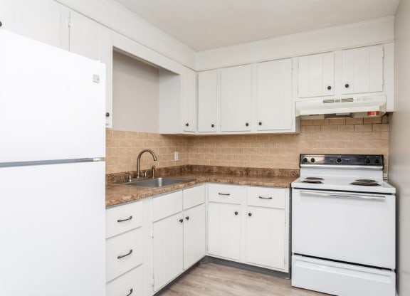 an empty kitchen with white appliances and white cabinets at Stonebridge, Ellington, CT