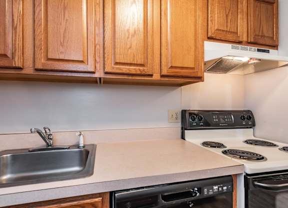 A kitchen with wooden cabinets and a stove top oven.