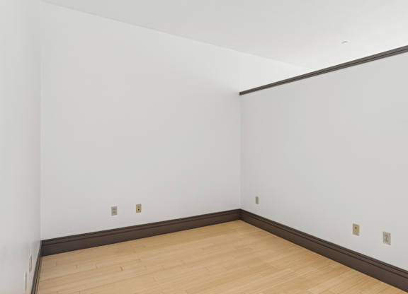 A room with white walls and a wooden floor.