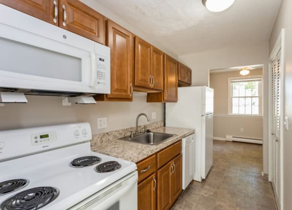 Kitchen view with white kitchen appliances and sink