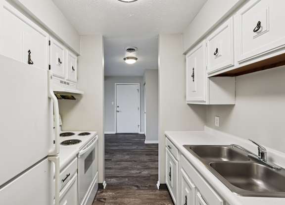 A kitchen with white appliances and cabinets.