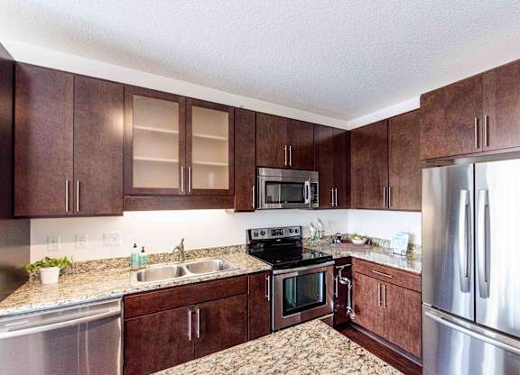 Kitchen with dark wood cabinets and granite countertops at 1800 Lake Apartments, Minneapolis